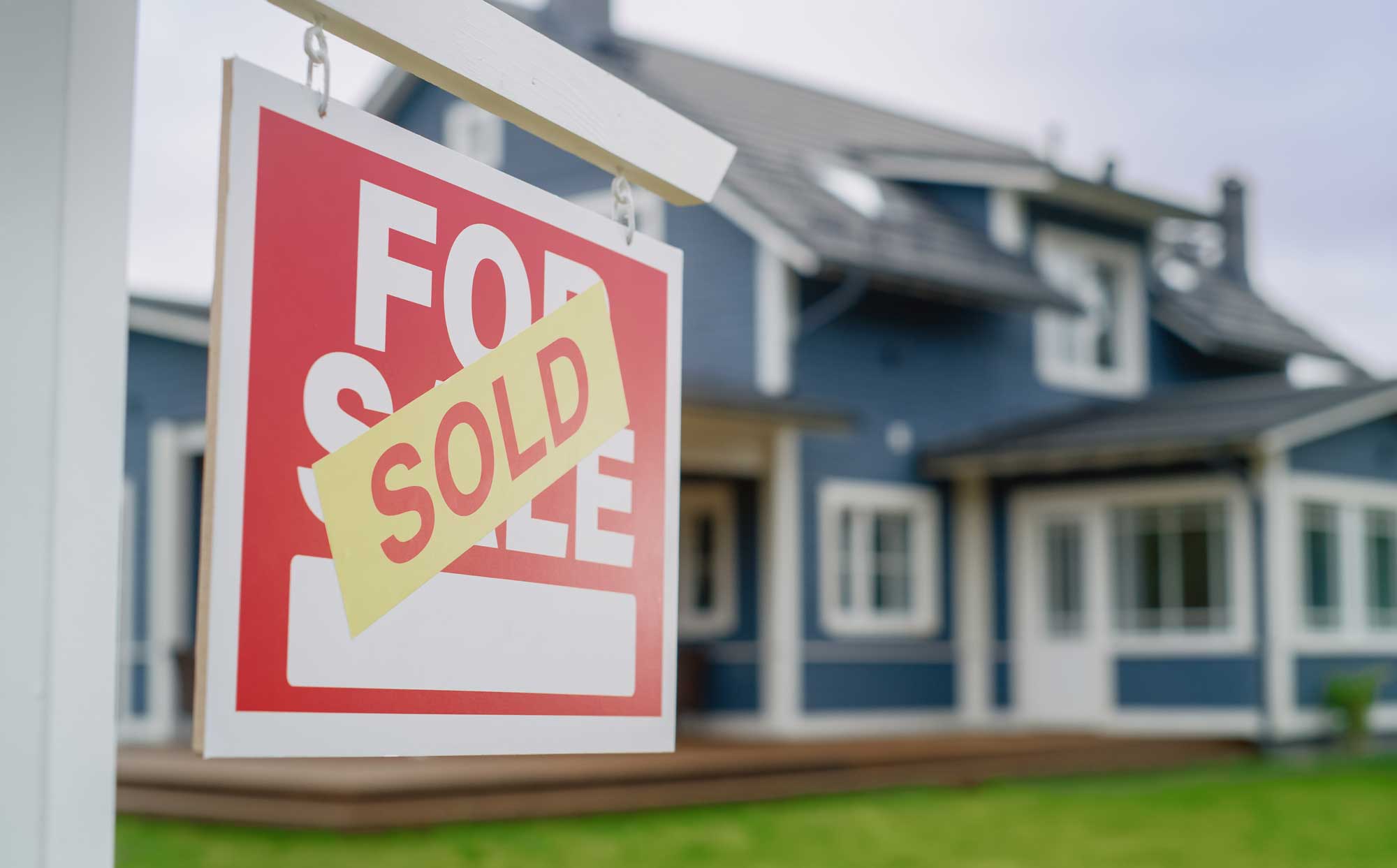 Blue house with a sold sign in front