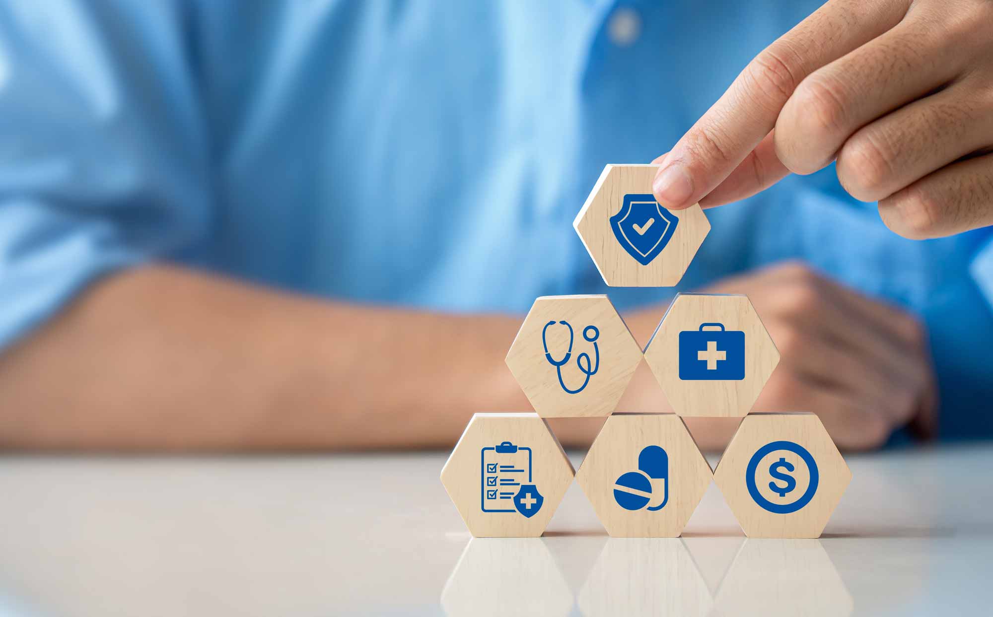Man stacking blocks with healthcare icons on them