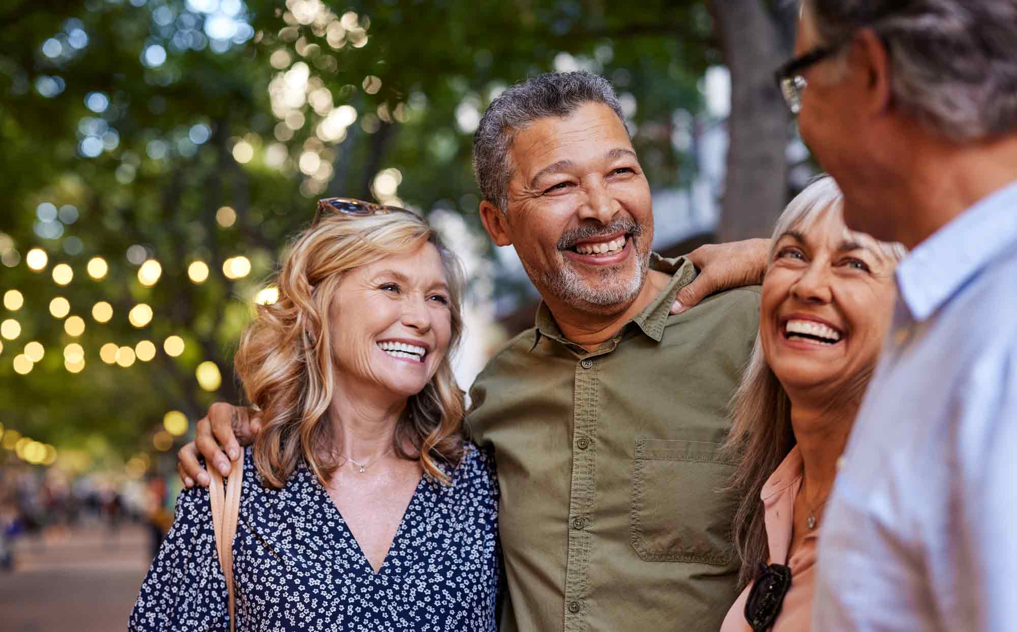 Group of middle-aged friends standing outdoors and laughing