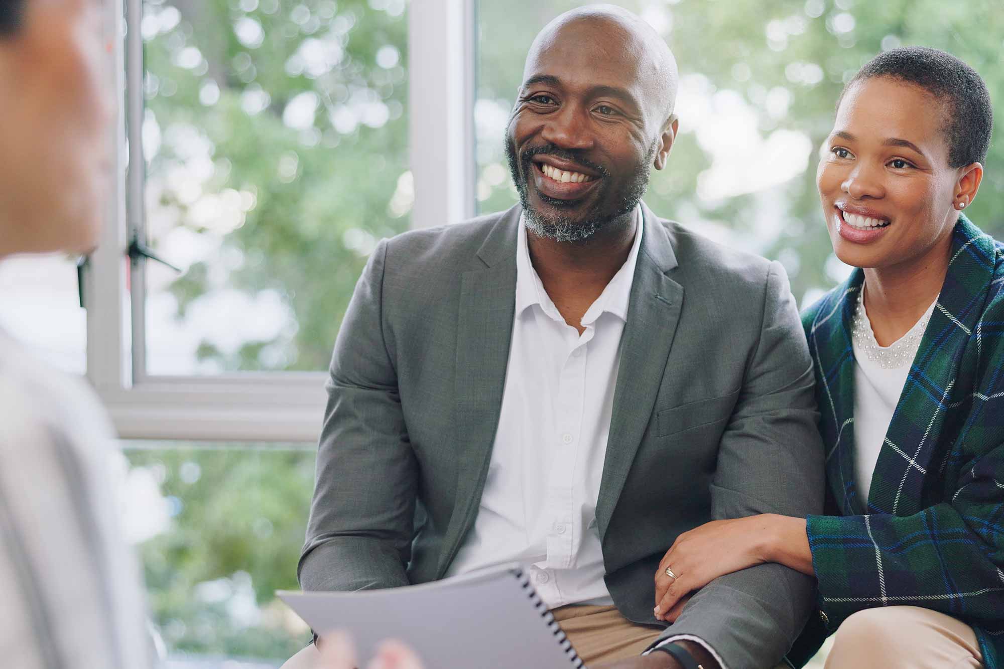 Couple on a couch talking with a financial advisor