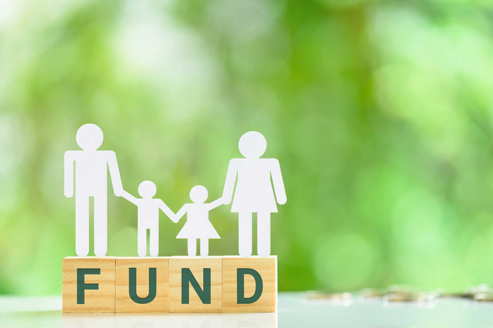 Blocks that spell out the word FUND with a cut-out paper family on top.