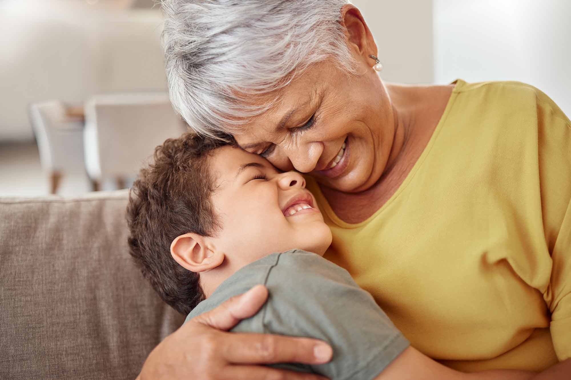 A grandmother giving her grandson a big hug and smiling