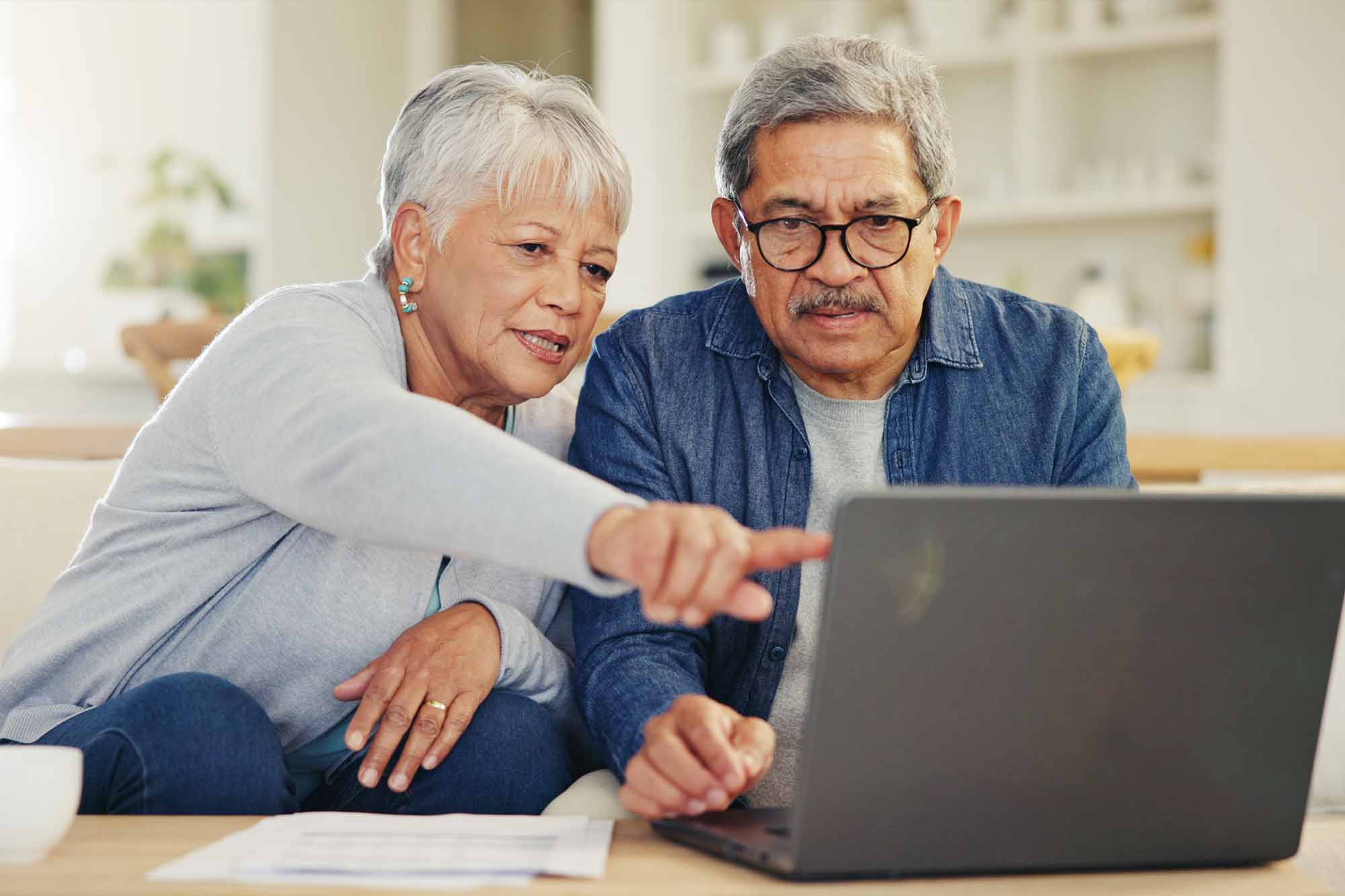An older couple looking serious as they look at their finances on a laptop